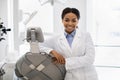 Professional black female stomatologist doctor posing at workplace in modern clinic