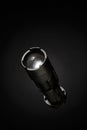Professional black flashlight upright on dark background with spotlight effect Royalty Free Stock Photo