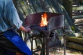 Professional blacksmith melting metal sticks on fire at work Royalty Free Stock Photo