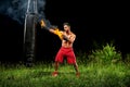 Professional boxer punching sandbag outdoors with his boxing glo Royalty Free Stock Photo