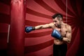 Professional boxing training with muscular athletic man. Active boxer in gym