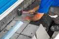 Professional bricklayer lays tiles. Hands of builder close-up with hammer. Repair of stone scaffolding of building