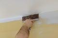 Professional builder smooths wall with spatula putty put on leveled surface of wall Royalty Free Stock Photo
