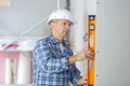 Professional builder with spirit level at construction site Royalty Free Stock Photo