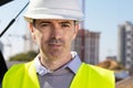 Professional builder standing in front of the construction site