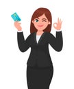 Professional business woman showing/holding credit/debit/ATM banking card and gesturing/making okay/ok sign, while winking eye.