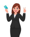 Professional business woman showing/holding credit/debit/ATM banking card and gesturing/making victory, v, peace or two sign. Royalty Free Stock Photo