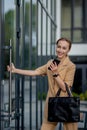 Professional business woman using mobile phone outdoors. Female texting on smart phone while walking outdoor in city Royalty Free Stock Photo