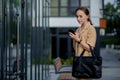 Professional business woman using mobile phone outdoors. Female texting on smart phone while walking outdoor in city. Royalty Free Stock Photo