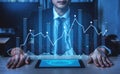 Professional Businessman Analyzing Financial Data with Digital Graphs and Trends Displayed on Tablet in Modern Office Royalty Free Stock Photo
