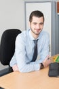 Professional businessman posing in his office and smiling at camera sitting at desk and working Royalty Free Stock Photo
