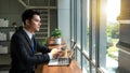 Professional Businessman By Window Working On Laptop In Coffee Shop Royalty Free Stock Photo