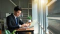 Professional Businessman By Window Working On Laptop In Coffee Shop Royalty Free Stock Photo