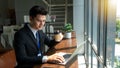 Professional Businessman By Window Working On Laptop In Coffee Shop Royalty Free Stock Photo