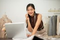 A professional, busy female tailor is talking on the phone with while working in her studio Royalty Free Stock Photo