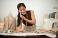 A professional, busy female tailor is talking on the phone with while working in her studio Royalty Free Stock Photo