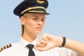 Professional captain pilot checking the time on her watch at the airport. Delay flight. Punctuality