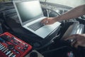 Professional car mechanic working in auto repair service using laptop Royalty Free Stock Photo