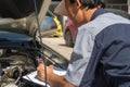 Professional car repair technicians inspect the engine according to the checklist documents to ensure that they are inspected