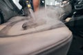 Professional seat wash with steam cleaner closeup. Detailing car cabin Royalty Free Stock Photo