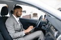 Professional Car Seller Sitting In Auto Taking Notes In Dealership