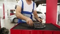 Auto mechanic installs clutch disc in workshop. Professional car service tech replaces clutch plate, examines release