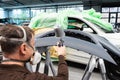 Professional car varnisher at work in a service station - Serie car repair workshop Royalty Free Stock Photo