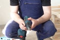 A professional carpenter with an electric drill in his hands. Carpentry work