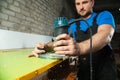 Professional carpenter processes the plastic edges of the countertop. The concept of furniture production Royalty Free Stock Photo