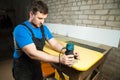 Professional carpenter processes the plastic edges of the countertop. The concept of furniture production Royalty Free Stock Photo