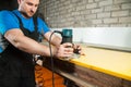 Professional carpenter processes the plastic edges of the countertop. The concept of furniture production Royalty Free Stock Photo