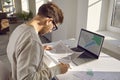 Professional cartographer working with printed cadastral map at table on his workplace.