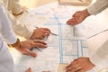 Professional cartographers working with cadastral map at table, closeup