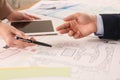 Professional cartographers working with cadastral map at table, closeup