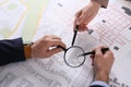 Professional cartographers working with cadastral map at table, closeup