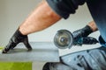 professional caucasian construction worker cutting ceramic tiles with angle grinder