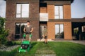 Professional Caucasian Gardener in His 40s Trimming Grass Lawn Using Modern Electric Cordless Mower. Landscaping Royalty Free Stock Photo