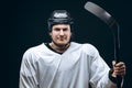 Handsome hockey player. Smiling at camera isolated on black background.