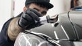 Professional ceramics handler apply different layers to the car using an applicator sponge, fiber immediately checking the effec
