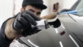 Professional ceramics handler apply different layers to the car using an applicator sponge, fiber immediately checking the effec