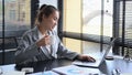 Professional chartered accountant drinking coffee and working with laptop computer at office desk Royalty Free Stock Photo