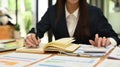 Professional chartered accountant woman working through finances, using calculator and making notes in her notebook Royalty Free Stock Photo