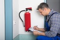 Professional Checking A Fire Extinguisher Royalty Free Stock Photo