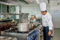 Professional chef adding ingredients to the dish while cooking