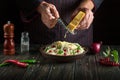 Professional chef adds hard cheese to spaghetti with spices in a plate. Menu or recipe for a delicious lunch for a hotel or Royalty Free Stock Photo