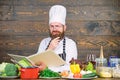 Professional chef in cook uniform. Happy bearded man cooking in kitchen. Dieting with organic food. Fresh vegetables Royalty Free Stock Photo