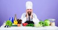 Professional chef in cook uniform. tired bearded man cooking in kitchen. Dieting with organic food. Fresh vegetables Royalty Free Stock Photo