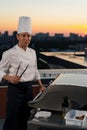 Professional chef cooking bbq on rooftop at sunset Royalty Free Stock Photo