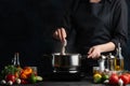 Professional chef cooking traditional asian dish with boiled octopuses. Backstage of preparing seafood on dark blur background. Royalty Free Stock Photo