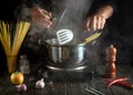 Professional chef cooks a delicious soup with vegetables and pasta in a hot pot in the kitchen. Delicious hotel food recipe Royalty Free Stock Photo